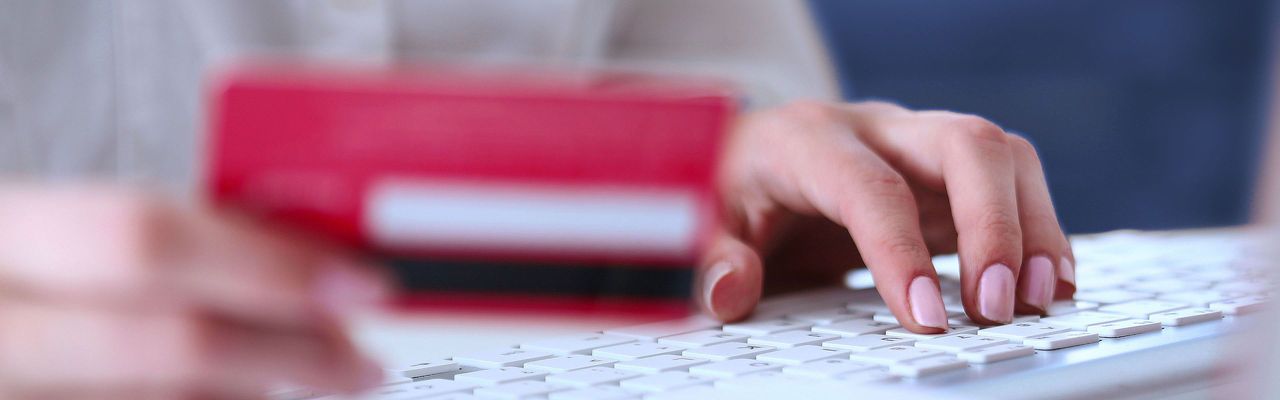Woman sitting at a desk holding a credit card