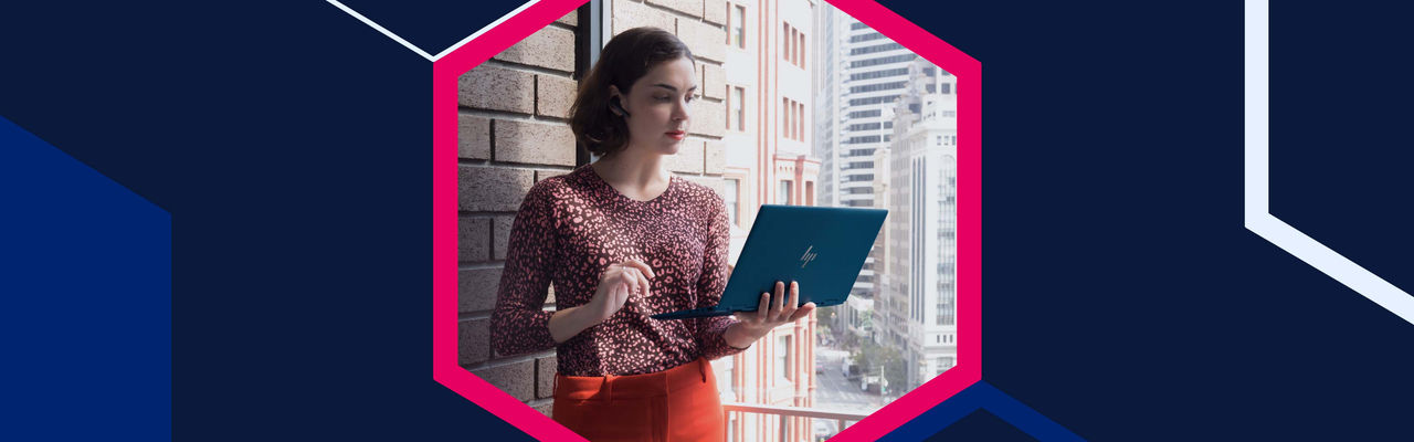 Woman holding an HP laptop on a city balcony