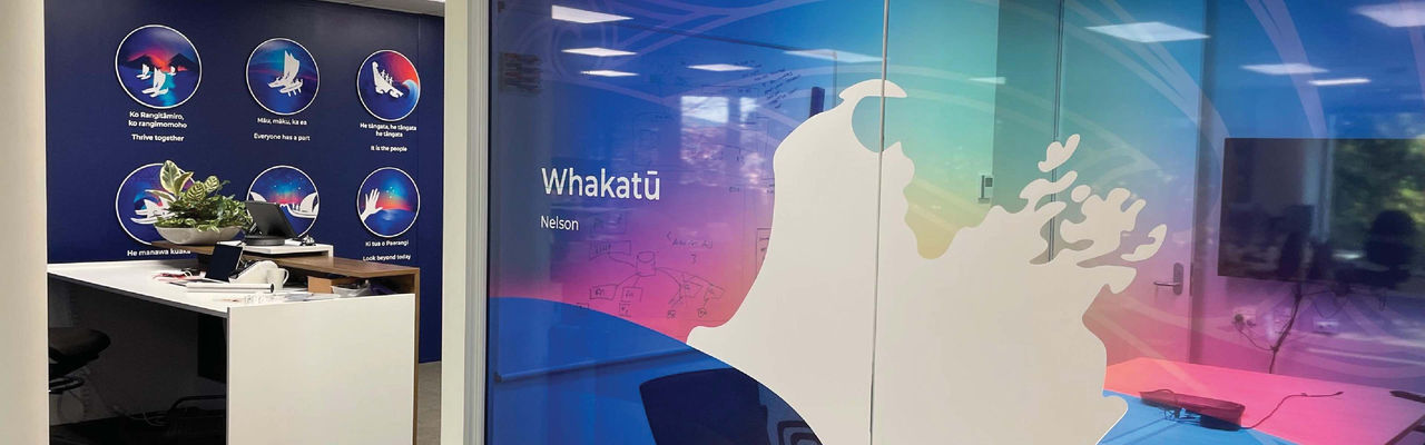 Datacom's Nelson office with Maori place name "Whakatu" written on the wall and Datacom values in the background