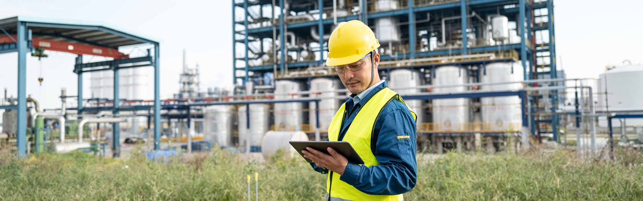 Engineer in the field in front of an energy plant