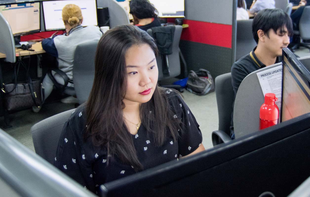 A Datacom graduate working at her computer