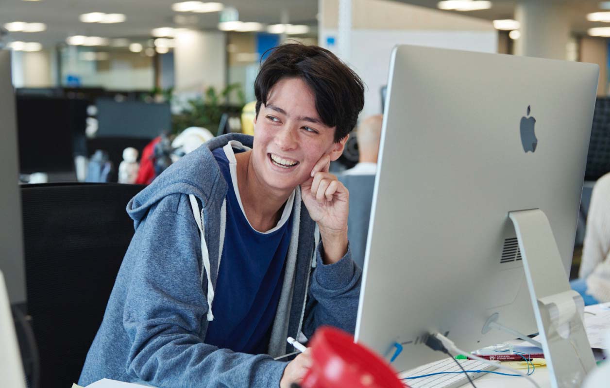 Datacom staff smiling at laptop