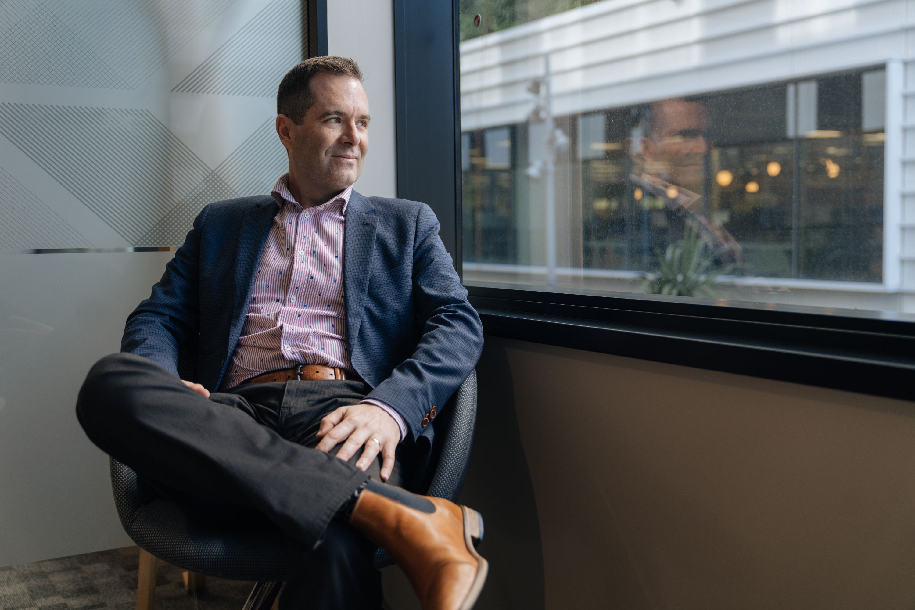 Photo of Darren Keall sitting and looking out of a window.