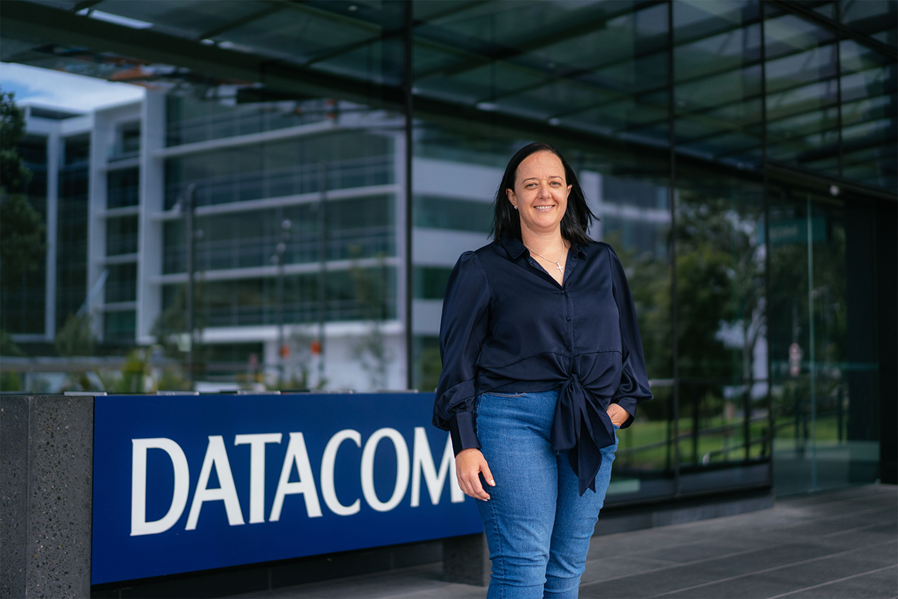 Datacom's Desiree Hutcheon in front of a blue Datacom sign