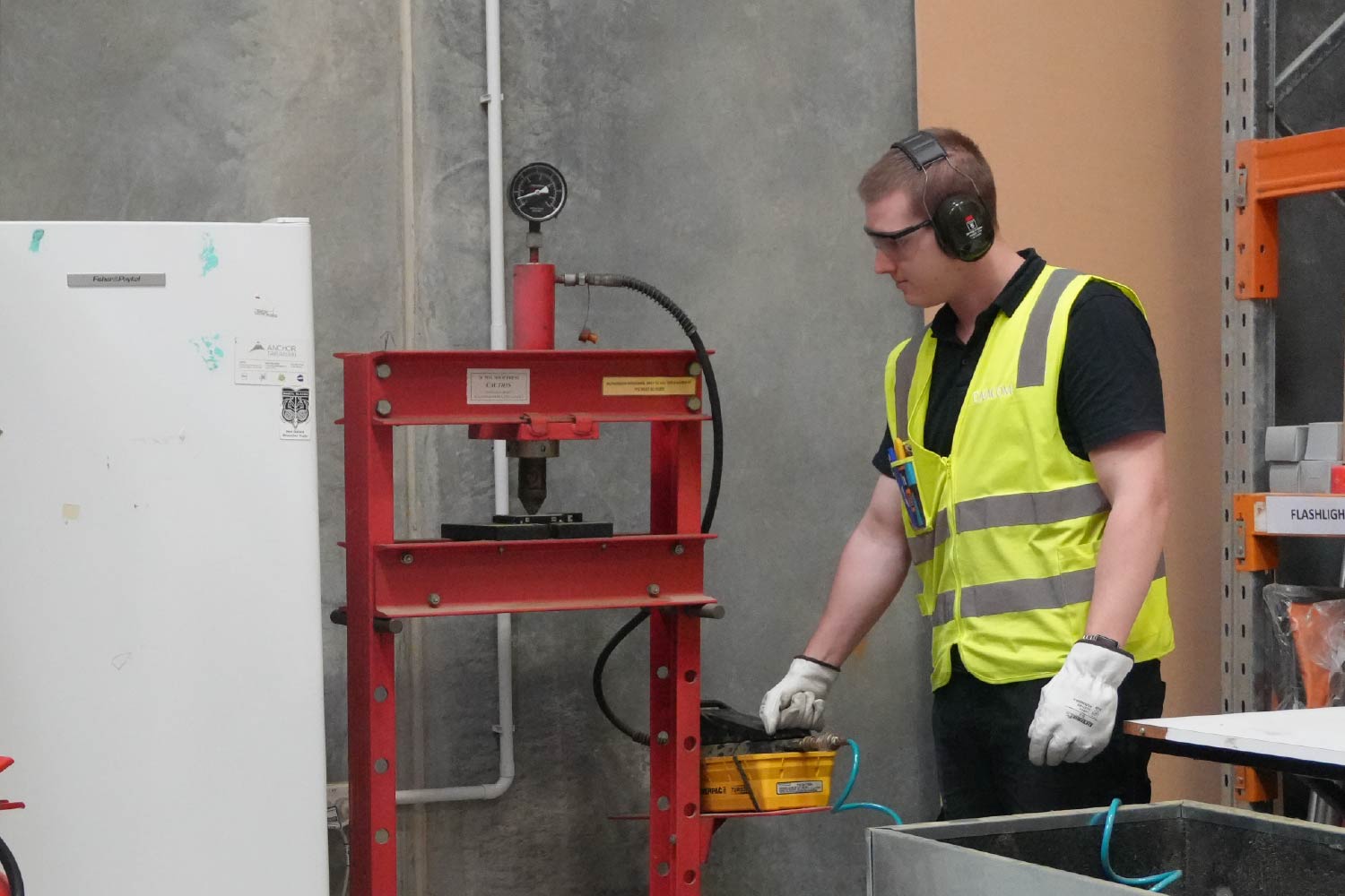 a man in the datacom warehouse wearing PPE and performing one of the many procedures behind e-waste recycling.