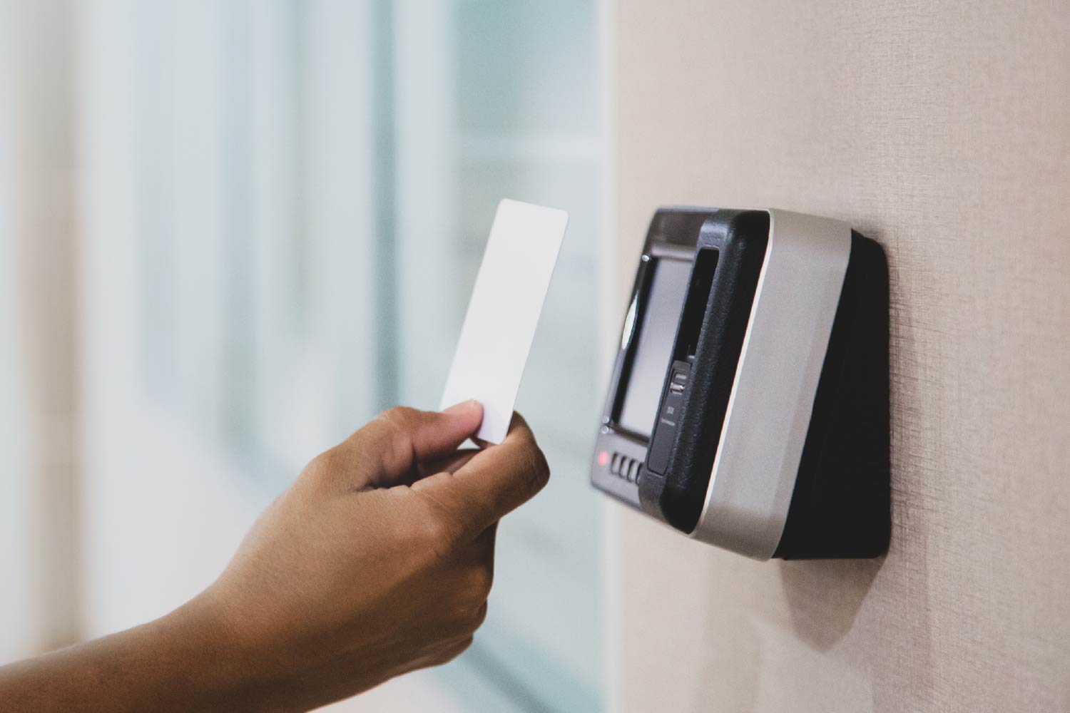 Hand using ID card on scan reader access control system for identity verification to open the door