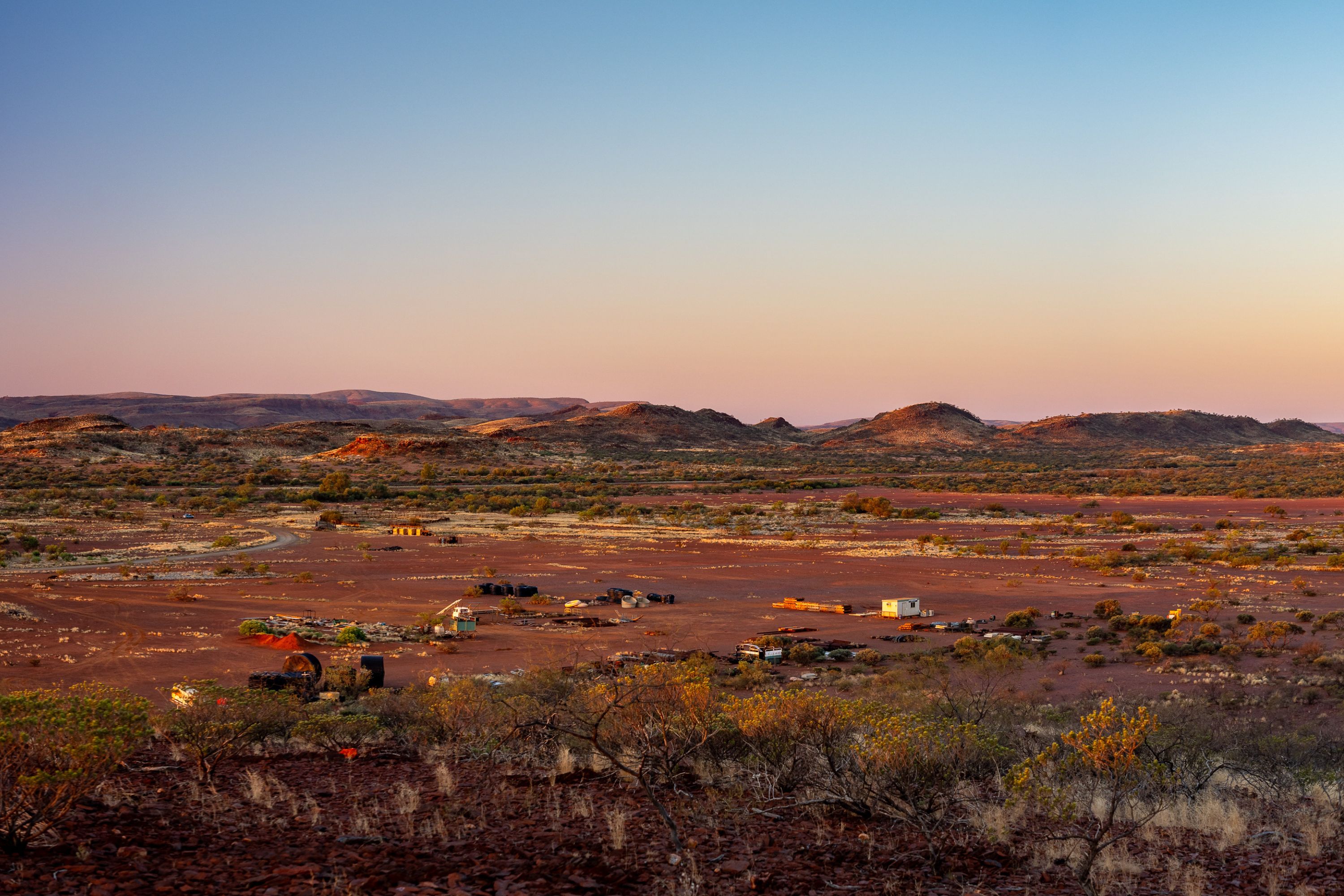 Landscape shot of farmland in Western Australia at sunset, surrounded by hills