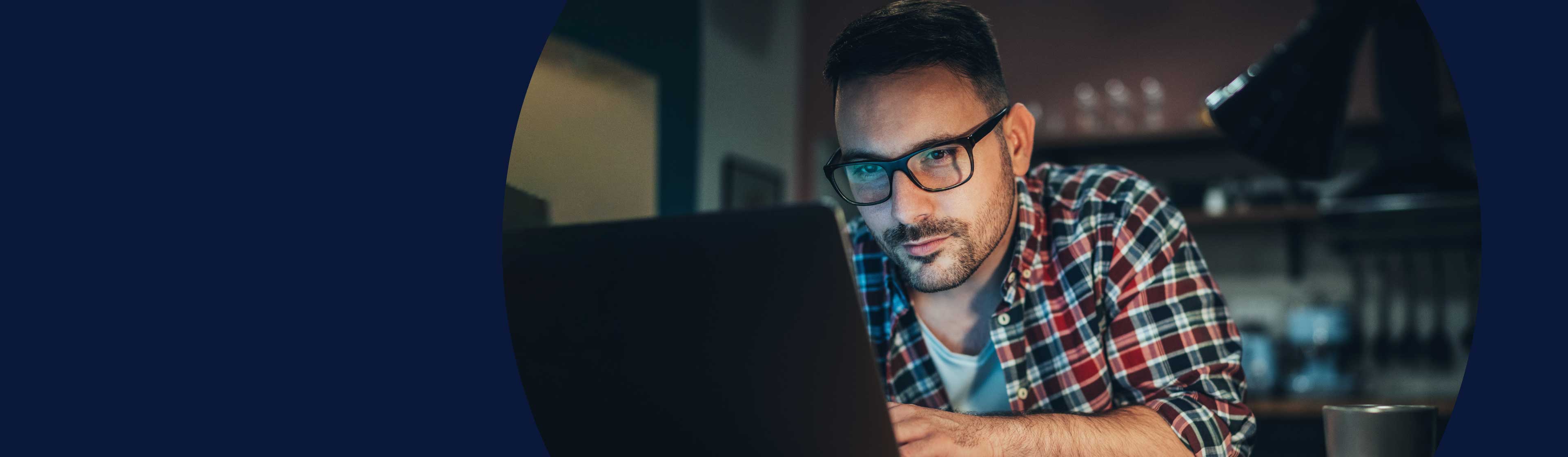 A man with glasses using a laptop