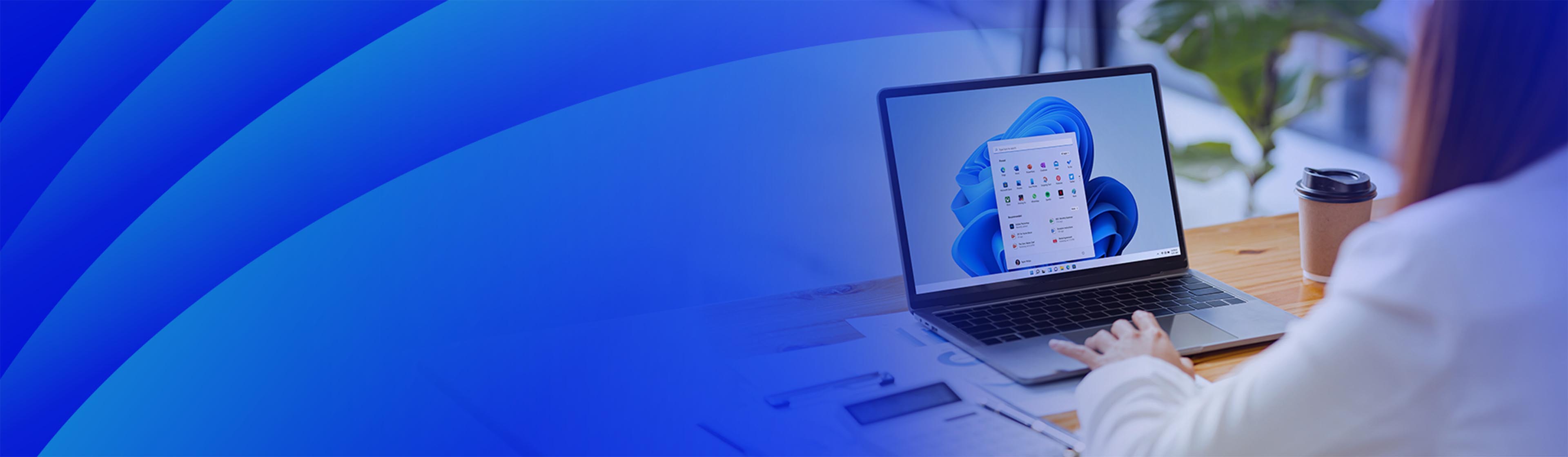 Photograph of a laptop displaying Windows 11 on a blue screen