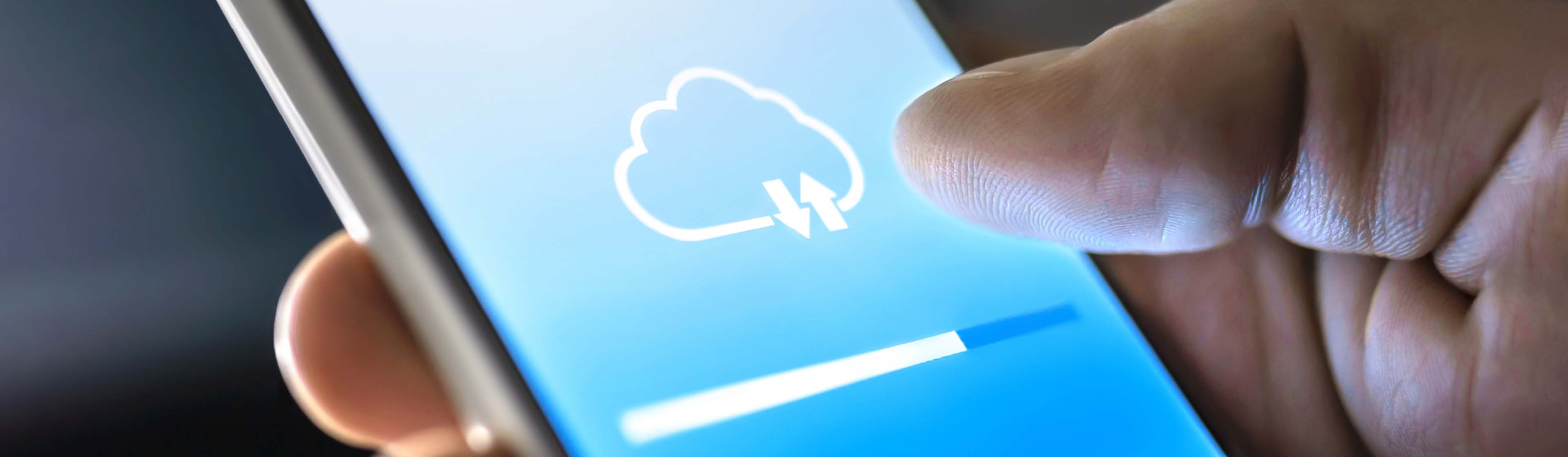 A person holding a phone with a cloud upload in progress