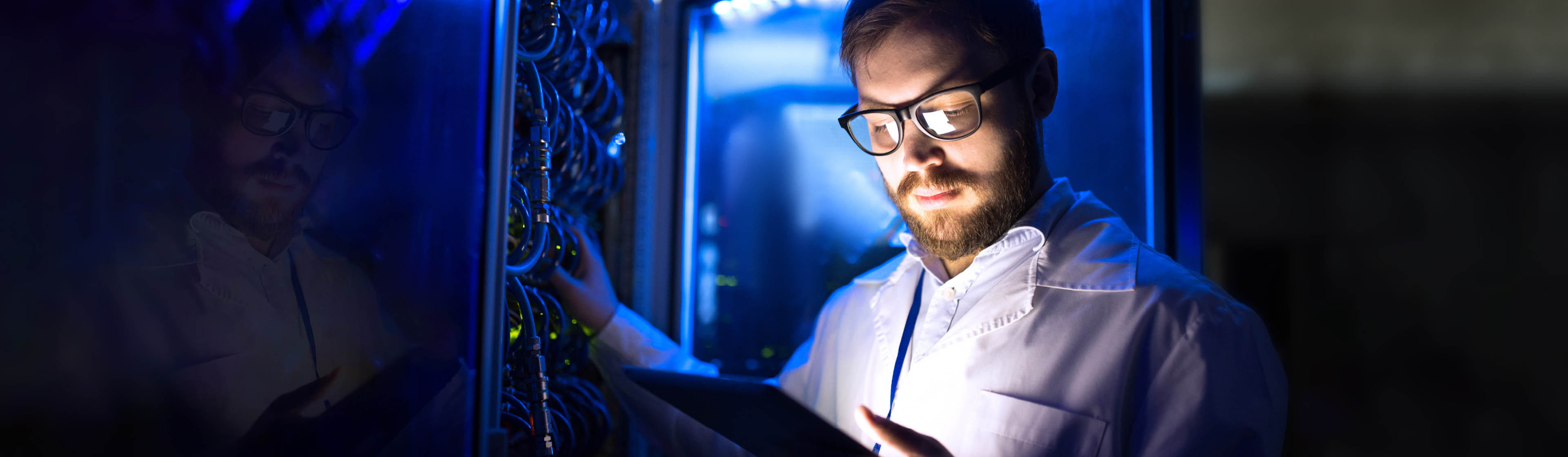 A cloud technician wearing glasses adjusting a server 
