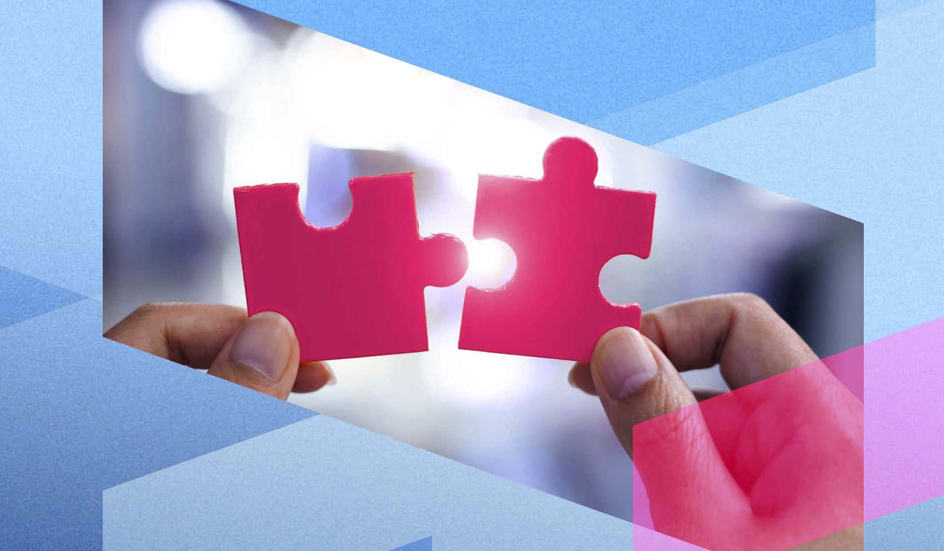 A pair of hands holding two pink puzzle pieces