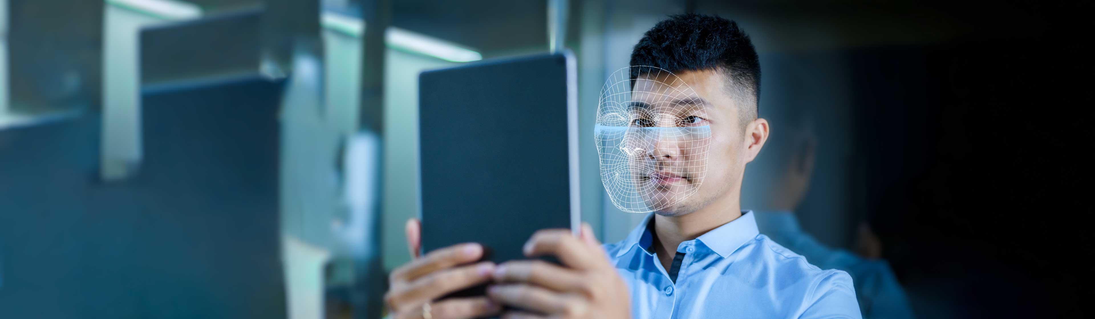 A man using AI for facial scanning on a tablet