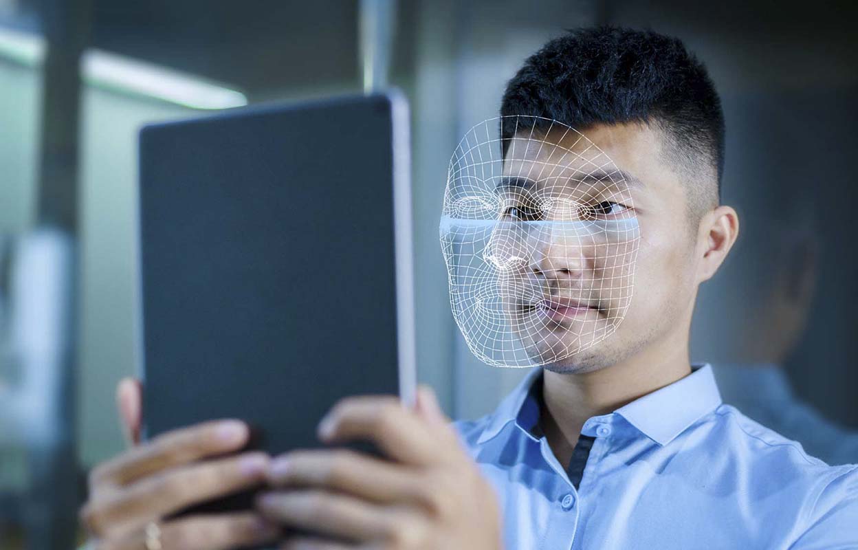 A man holding a tablet up in front of his face
