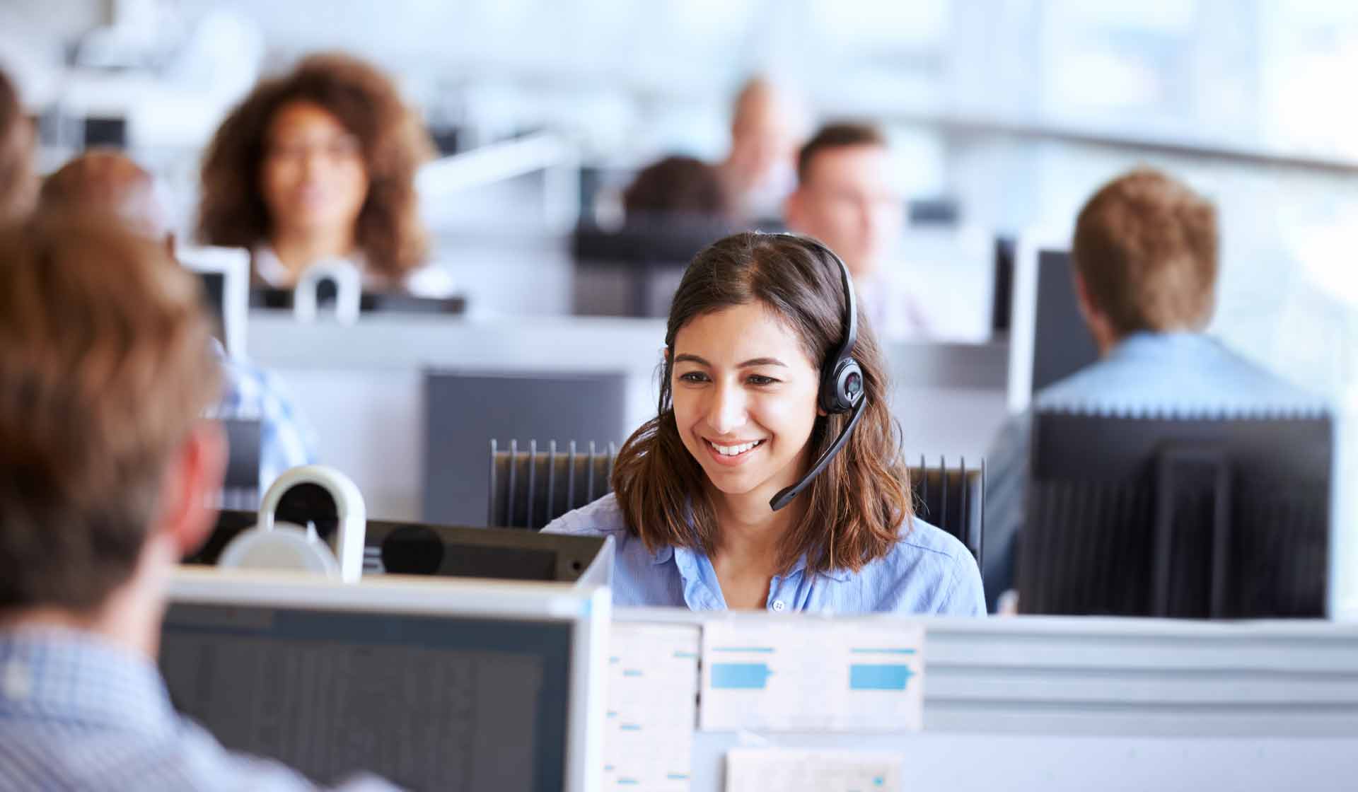 A smiling customer service representative using CRM tools