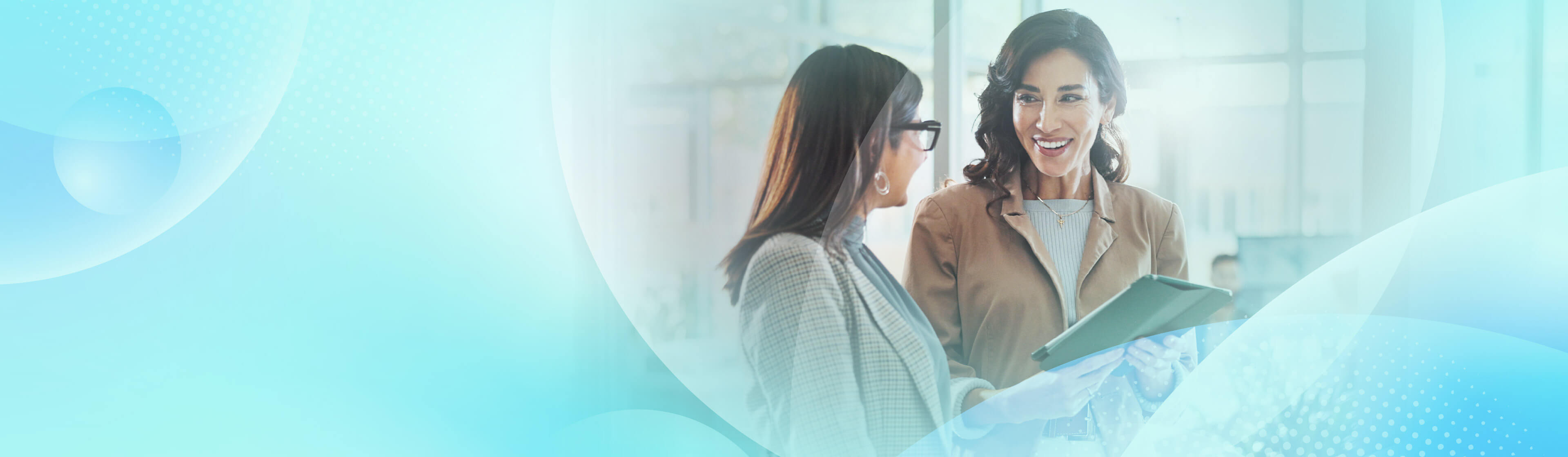 Two professional women smiling and discussing AI on a tablet, with a light blue abstract pattern overlaying the image