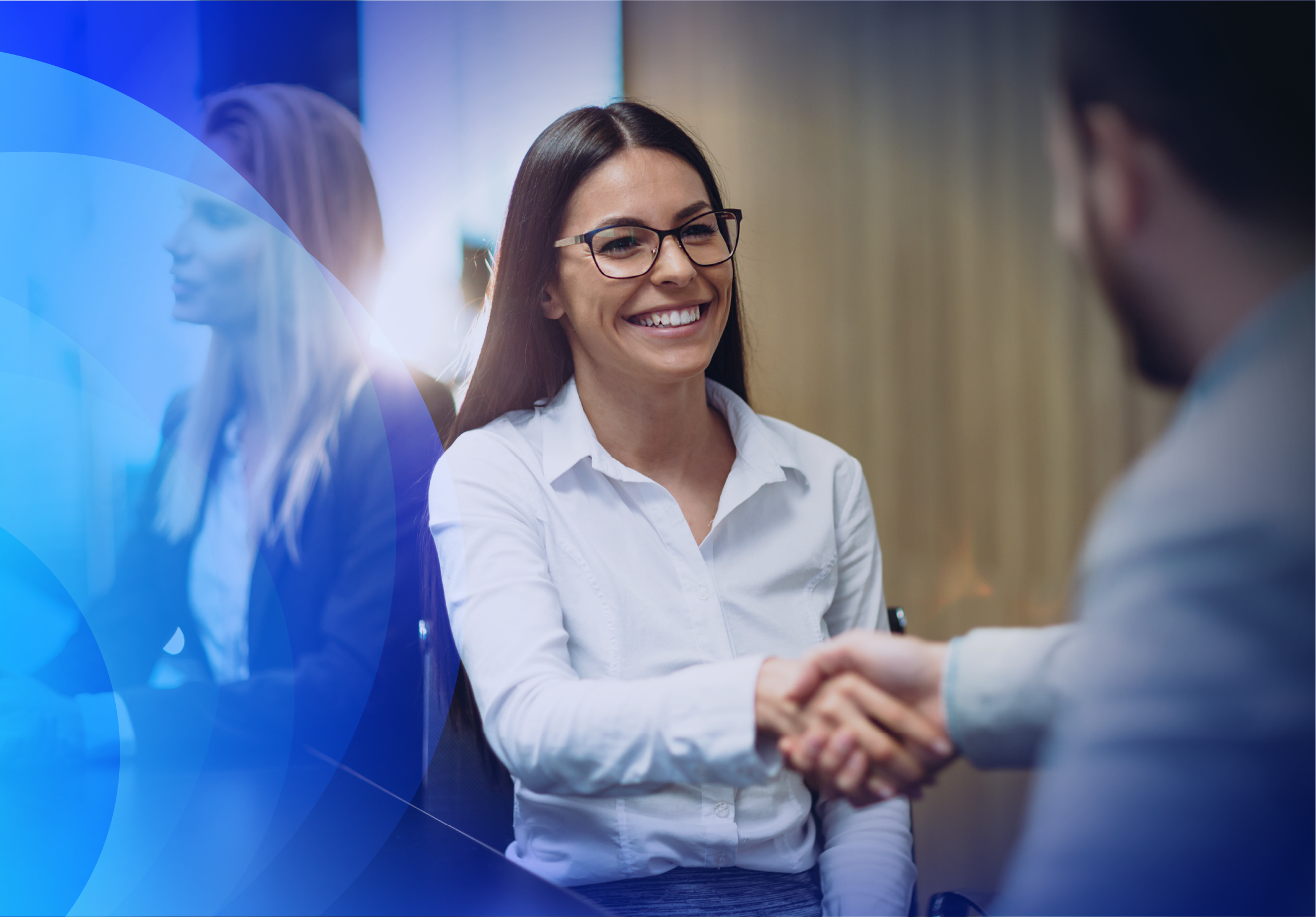 A smiling woman wearing glasses shaking hands