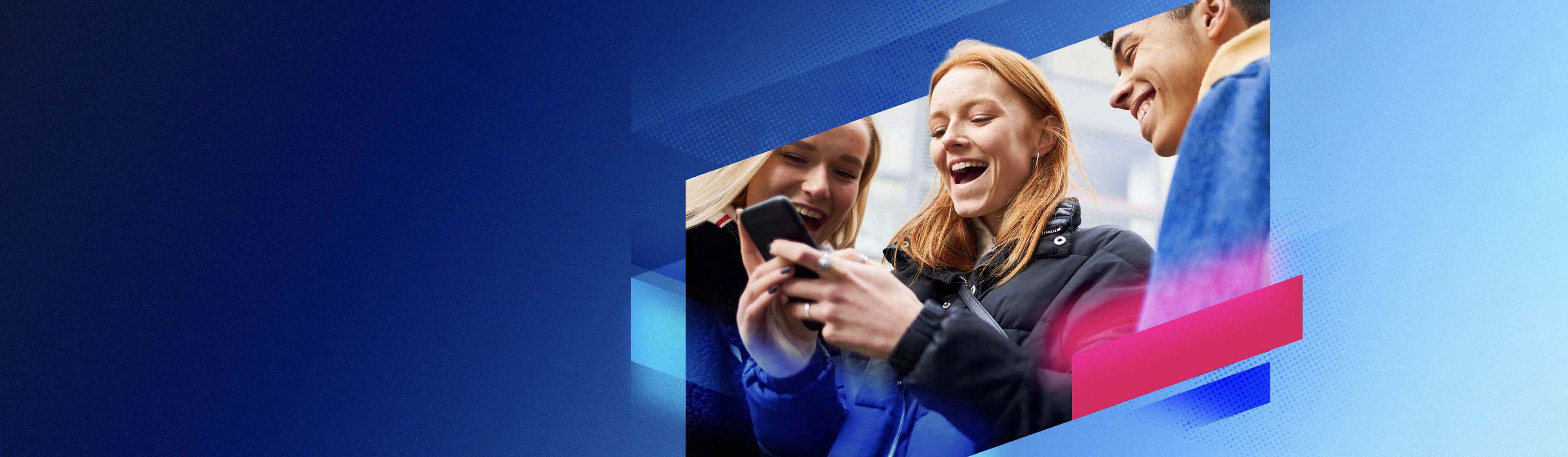 Two young girls smiling looking at a phone
