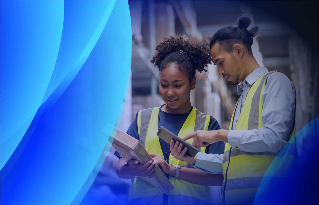 Two workers reviewing software licensing on a tablet in a warehouse