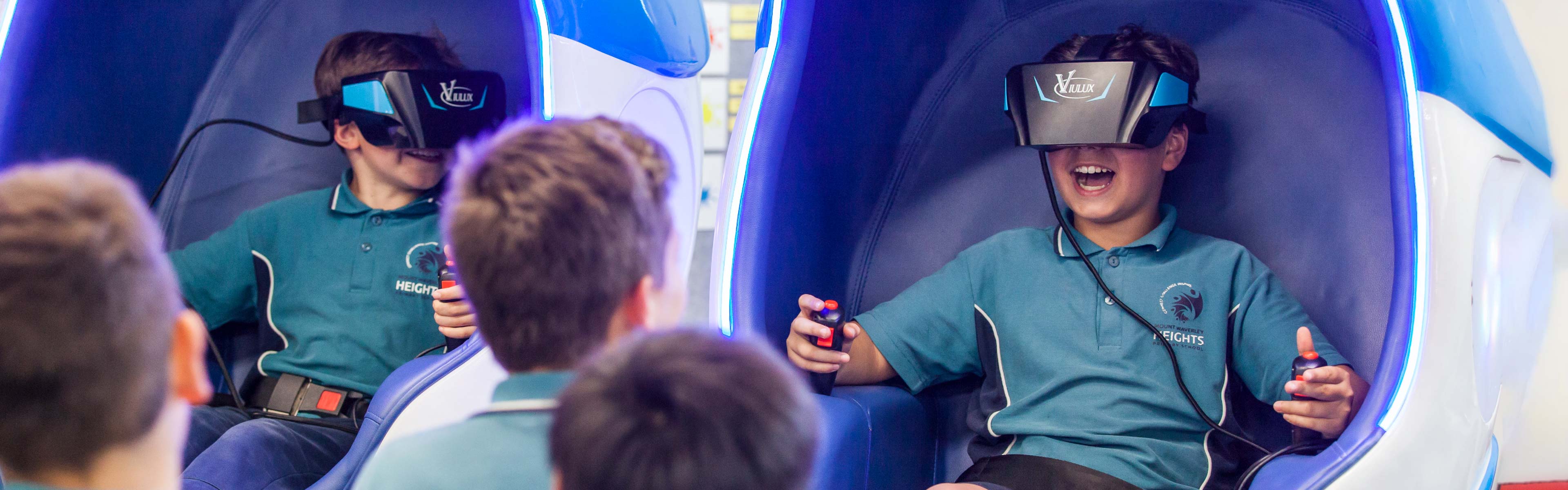 Smiling young student sitting in a VR booth wearing a VR headset