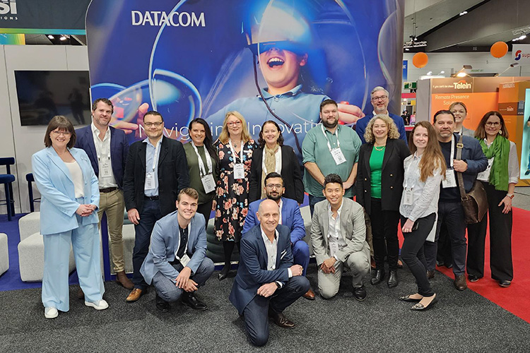 Photo of the Datacom team in front of the Datacom stand