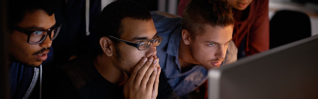 concerned men leaning into a computer screen