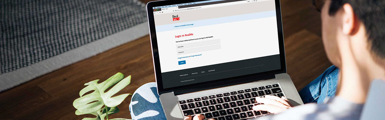 A person using a laptop to access the RealMe website