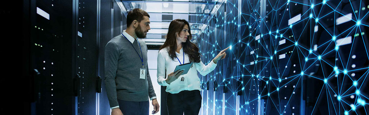 Man and woman standing in a server room.